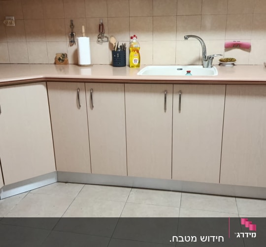 מטבח עם ארונות כיור ותנור